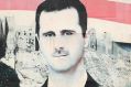 Pro-government supporters hold up the national Syrian flag and pictures of Syrian President Bashar al-Assad in Aleppo ...