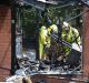 Firefighters survey the scene at a house fire at 3 Ranken Loop, Belconnen.