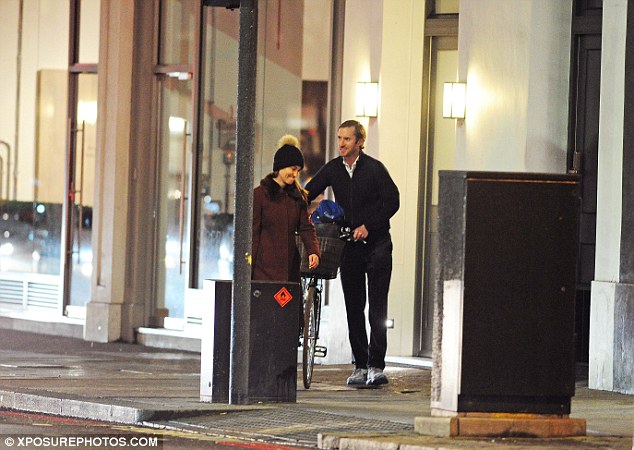 James was seen pushing Pippa's bike as the couple walked along the street