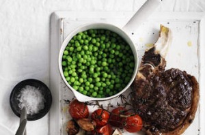 Summer grillin': Rib-eye with peas and roasted tomatoes.