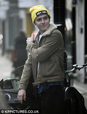 Behind the wheel: Brooklyn casually made his way to his car and took a glance around before climbing into the lavish motor