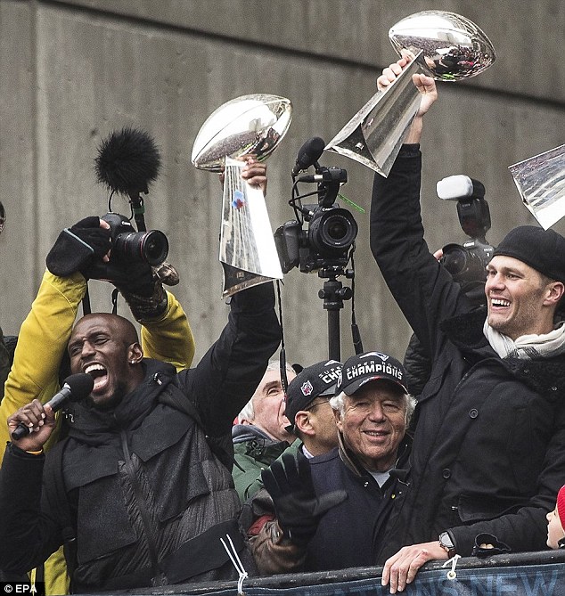 McCourty (left) celebrates his Super Bowl win at the victory parade in Boston alongside team owner Robert Kraft (center) and MVP Tom Brady (right)