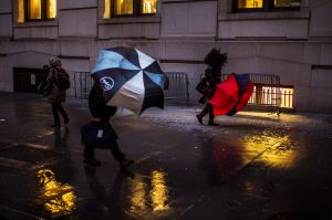 People walk against heavy wind in downtown New York, Monday, Jan. 23, 2017. From California to the Deep South to the ...