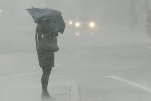 A woman waits to cross a street during a severe thunderstorm in Sydney.