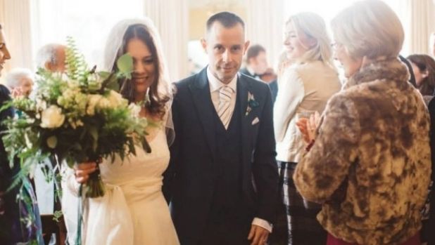 Angelia Cuming and her husband Paul walk down the aisle on their wedding day.