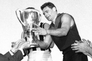 Melbourne's Ron Barassi receives the 1964 premiership cup.