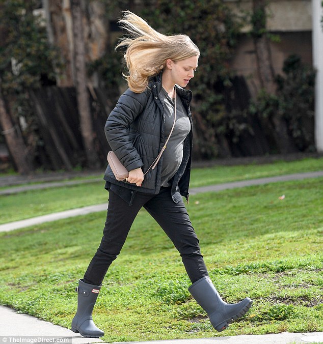 Windy day: The actress's hair blew as she added a handbag with rain boots to her ensemble