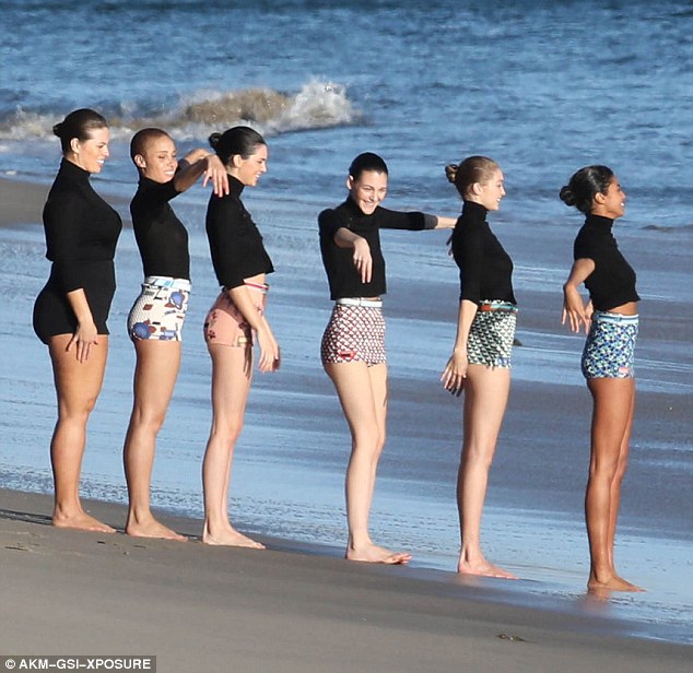 Candid shots: Ashley, Kendall and Gigi lark about on the beach with models Adwoa Aboah, Vittoria Ceretti and Imaan Hammam in a paparazzi shot of the photoshoot in December. She is dressed in a black polo and all black shorts 