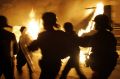 French riot police officers run past a burning truck in Paris suburb, Aulnay-sous-Bois during the 2005 riots.