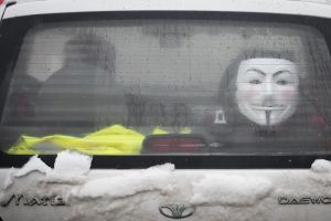 BUCHAREST, ROMANIA - FEBRUARY 08: A car drives past with a Guy Fawkes mask displayed in the rear window in central ...