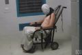 A teenage Dylan Voller has a hood placed over his head and is strapped to a chair at the Don Dale Detention Centre in the NT.