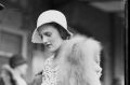 Glass plate photo of Countess of Jersey Patricia Kenneth Child-Villiers dressed in a fox fur signing a card, Sydney, ...