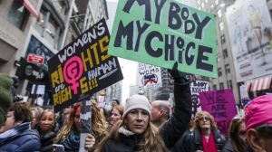 Demonstrators hold signs while marching towards Trump Tower during the Women's March in New York, U.S., on Saturday, ...