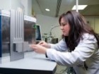 Scientist Nyssa Drinkwater at work in her laboratory wearing a white coat.