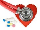 Closeup stethoscope on heart cutout next to pills