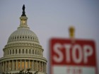 A stop sign is seen at dusk next to the US Congress building