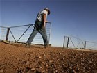 Farmer John Ridley closes a gate on his farm near the town of West Wyalong, 2007