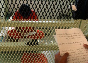 File - The Combatant Status Review Tribunal Notice is read to a detainee at Guantanamo Bay, Cuba, July 13, 2004.