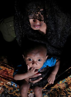 Mohsena Begum, a Rohingya who escaped to Bangladesh from Myanmar, holds her child at an unregistered refugee camp in ...