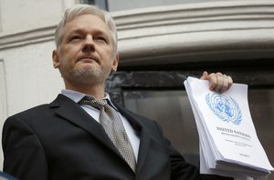 File - This is a Friday, Feb. 5, 2016 file photo of WikiLeaks founder Julian Assange holds a U.N. report as he speaks on the balcony of the Ecuadorian Embassy in London.