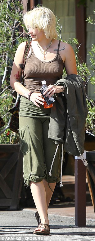 Not shy: Her outfit featured a brown ribbed tank top sans bra, some olive-colored cargo capris and strappy, flat sandals