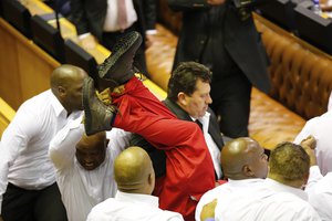 Economic Freedom Fighters in red are forcibly removed from parliament in Cape Town, South Africa, Thursday, Feb. 9, 2017. Parliament descended into chaos with opposition lawmakers denouncing President Jacob Zuma as a