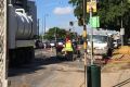 Queensland Urban Utilities workers fix a burst water main on Kingsford Smith Drive.