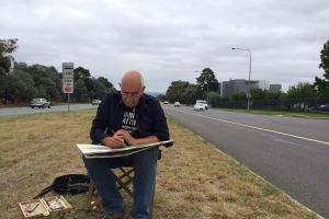 Canberra artist Christopher Oates works on a painting in the middle of six-lane Adelaide Avenue.