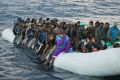 Migrants and refugees wait to be helped by members of the Spanish NGO Proactiva Open Arms, as they crowd aboard a rubber ...