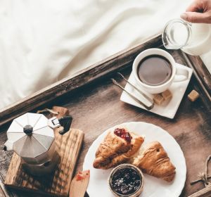 Woman having breakfast in bed. Window light