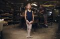 Eight-year-old Alexandra Shaw  in the factory behind Salvios Dancing Shoes, in Randwick, with Phil Salvio toiling in the ...