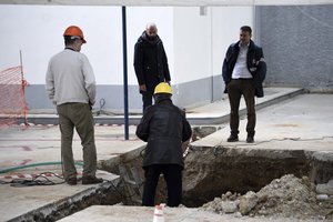 Experts check the location where an unexploded World War II bomb was found 5 meters (over 16 feet) deep, at a gas station in the northern Greek city of Thessaloniki, on Thursday, Feb. 9, 2016