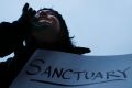 Demonstrators chant against US President Donald Trump's executive order  on "sanctuary cities" outside City Hall in ...