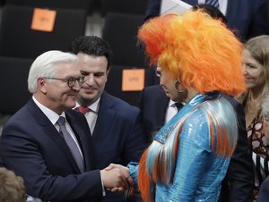 Newly elected German President Frank-Walter Steinmeier, left, is congratulated by Drag Queen Olivia Jones, member of the electoral college, when a German parliamentary assembly came together to elect the country's new president in Berlin, Germany, Sunday, Feb. 12, 2017.