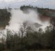 Crews work to move two electric transmission line towers as a precaution should the Oroville Dam emergency spillway need ...