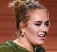 Adele collects the Grammy for Song of the Year for <i>Hello</i>.