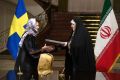 Sweden's feminist trade minister Ann Linde dons the hijab and wears a black cloak like her Iranian counterpart.