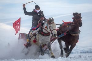 CILDIR, TURKEY - FEBRUARY 04: A man whips his horses as he takes part in the horse and sled racing across the frozen ...