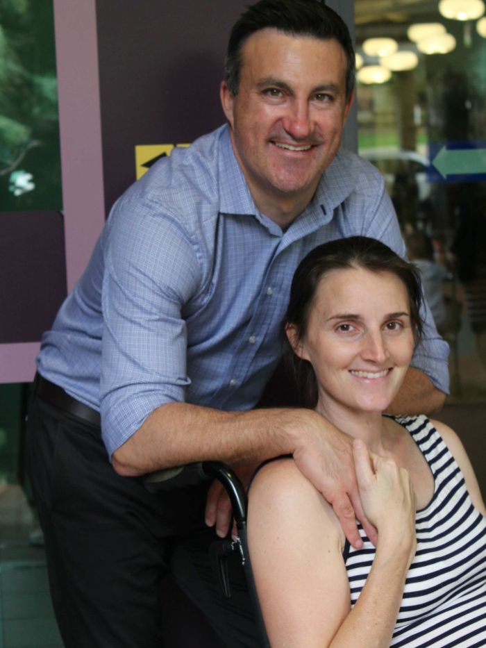 Dave Fitzgibbon holds his wife Claudine's hand in a portrait.