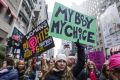 Demonstrators hold signs while marching towards Trump Tower during the Women's March in New York, U.S., on Saturday, ...