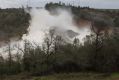 Crews work to move two electric transmission line towers as a precaution should the Oroville Dam emergency spillway need ...