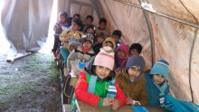 Syrian children in refugee camp classroom tent