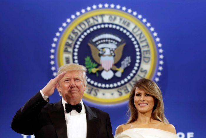 President Donald Trump salutes with his wife Melania