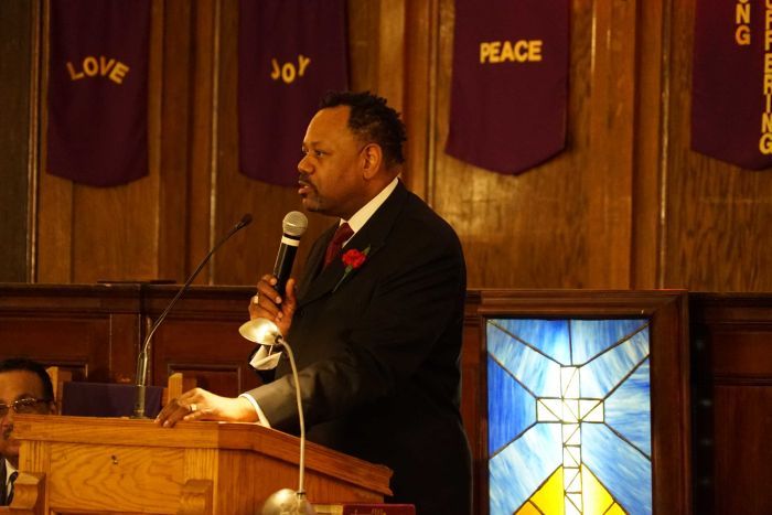 LaRue Kidd speaks into a microphone in a church