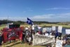 A group of protesters holding banners, flags and signs.