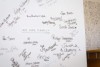 A whiteboard with people's names and signatures written on it and the words 'We are family'