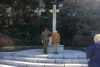 An Australian Army officer (left) salutes a headstone alongside veteran Jack Hopgood (right)