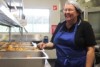 woman standing with a tray of muffins