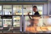 a young woman behind the counter of a cafe