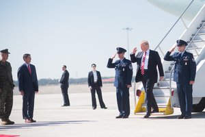 President Donald Trump returns a salute while he's greeted by National Security Advisor Michael Flynn and Gen. Joseph F. Dunford, the chairman of the Joint Chiefs of Staff, upon his arrival at MacDill, AFB, FL, Feb. 6, 2017